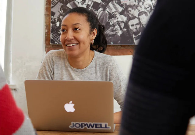 Tani Brown, Chief of Staff at Jopwell, seated in front of her laptop.